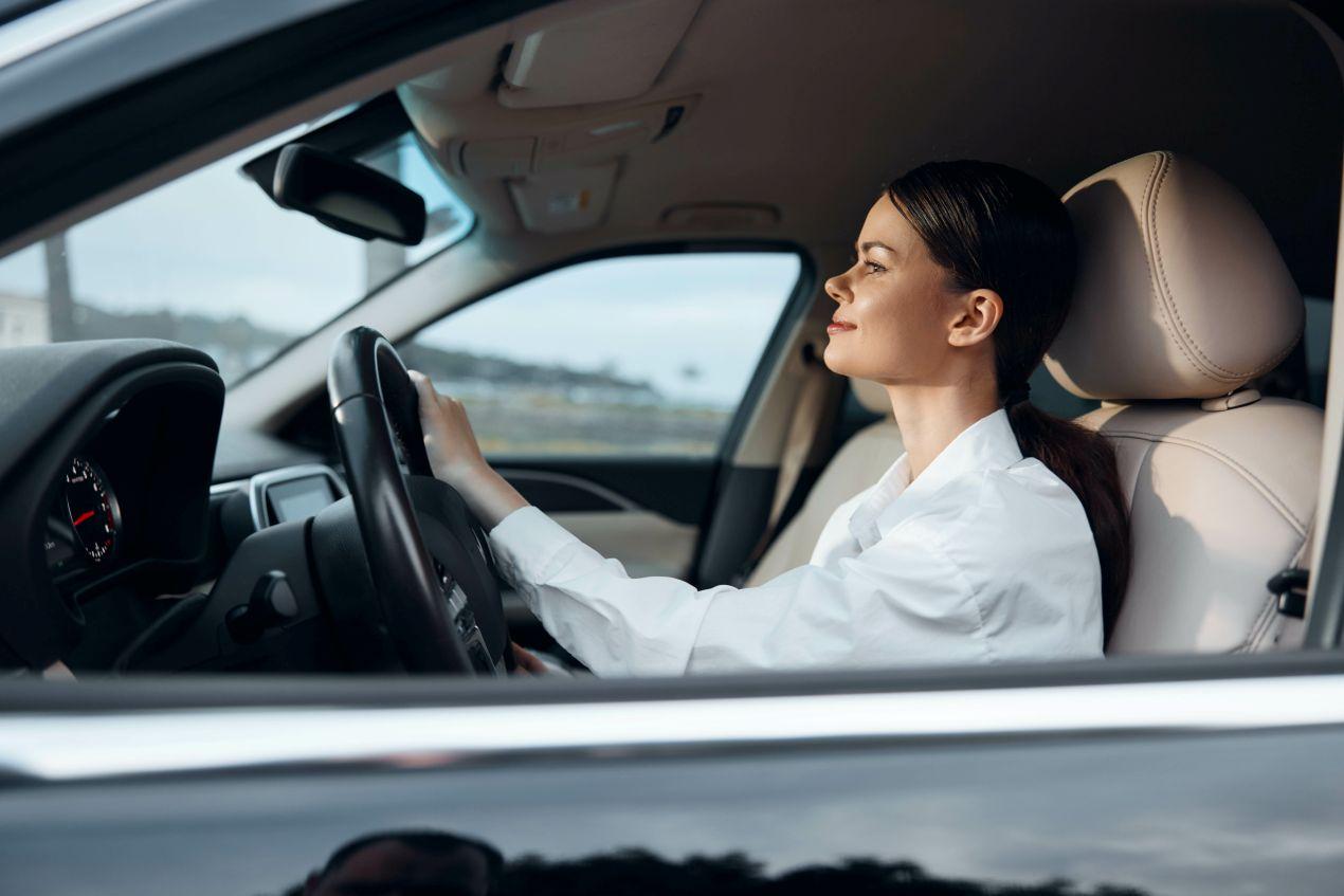 Eine konzentrierte Frau am Steuer ihres Autos – Fahrtraining und Schleuderkurs Schweiz für mehr Sicherheit auf winterlichen Straßen.