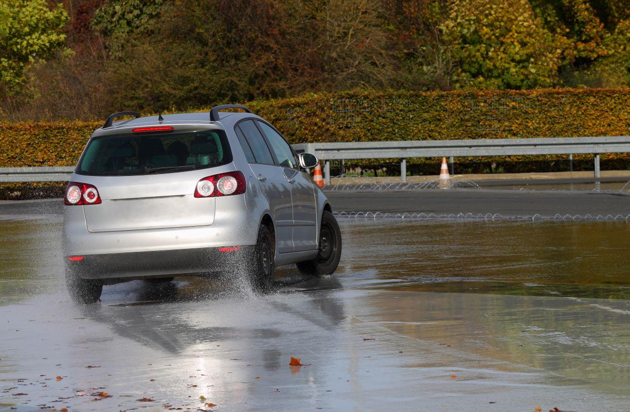 Ein Auto auf einer nassen Teststrecke beim Schleuderkurs Schweiz – sicheres Fahrtraining für rutschige Straßenbedingungen.