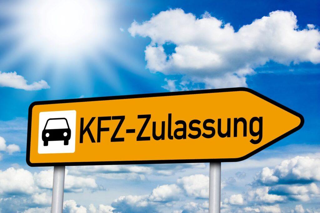 Gelber Wegweiser mit der Aufschrift „KFZ-Zulassung“ vor blauem Himmel – zeigt den Weg zur Fahrzeuganmeldung mit einem Zulassungsdienst.