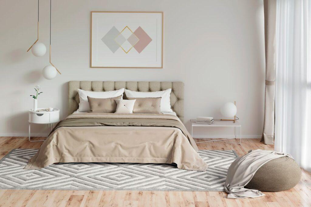 Helles, modernes Schlafzimmer mit beige-grauem Bett, in dem ein Matratzenschutz diskret unter der Bettwaesche verborgen ist