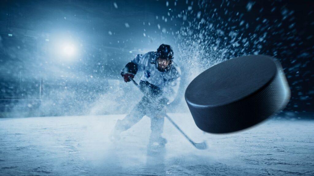 Eishockey Puck im Fokus bei Hochgeschwindigkeitsschuss auf dem Eis