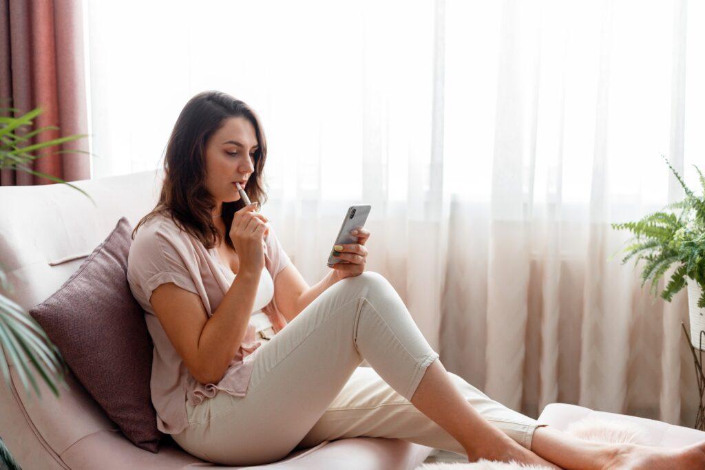 Frau dampft entspannt im Hotelzimmer | Elf Bar Vape