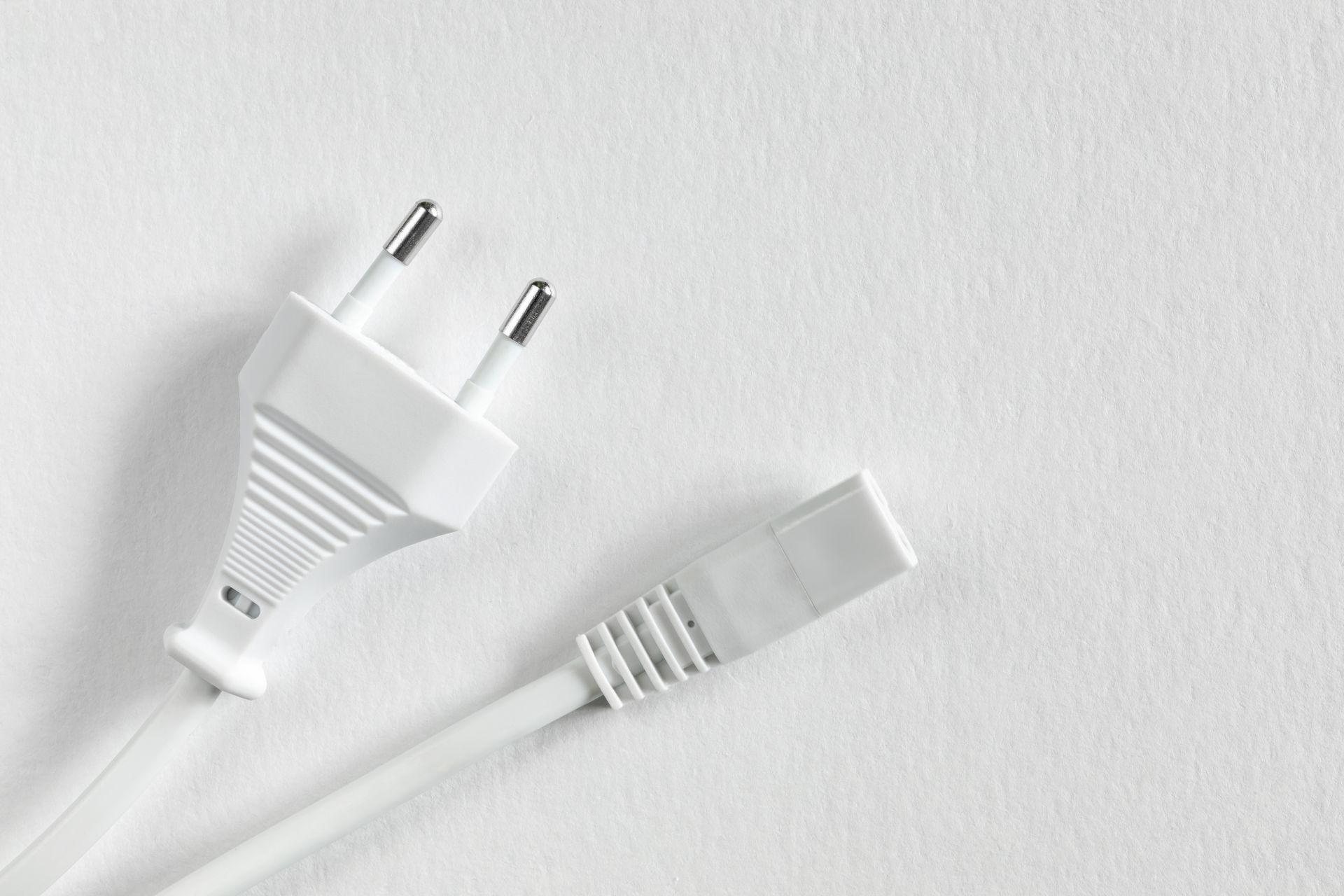 Weisser Eurostecker Typ C liegt auf hellem Untergrund 