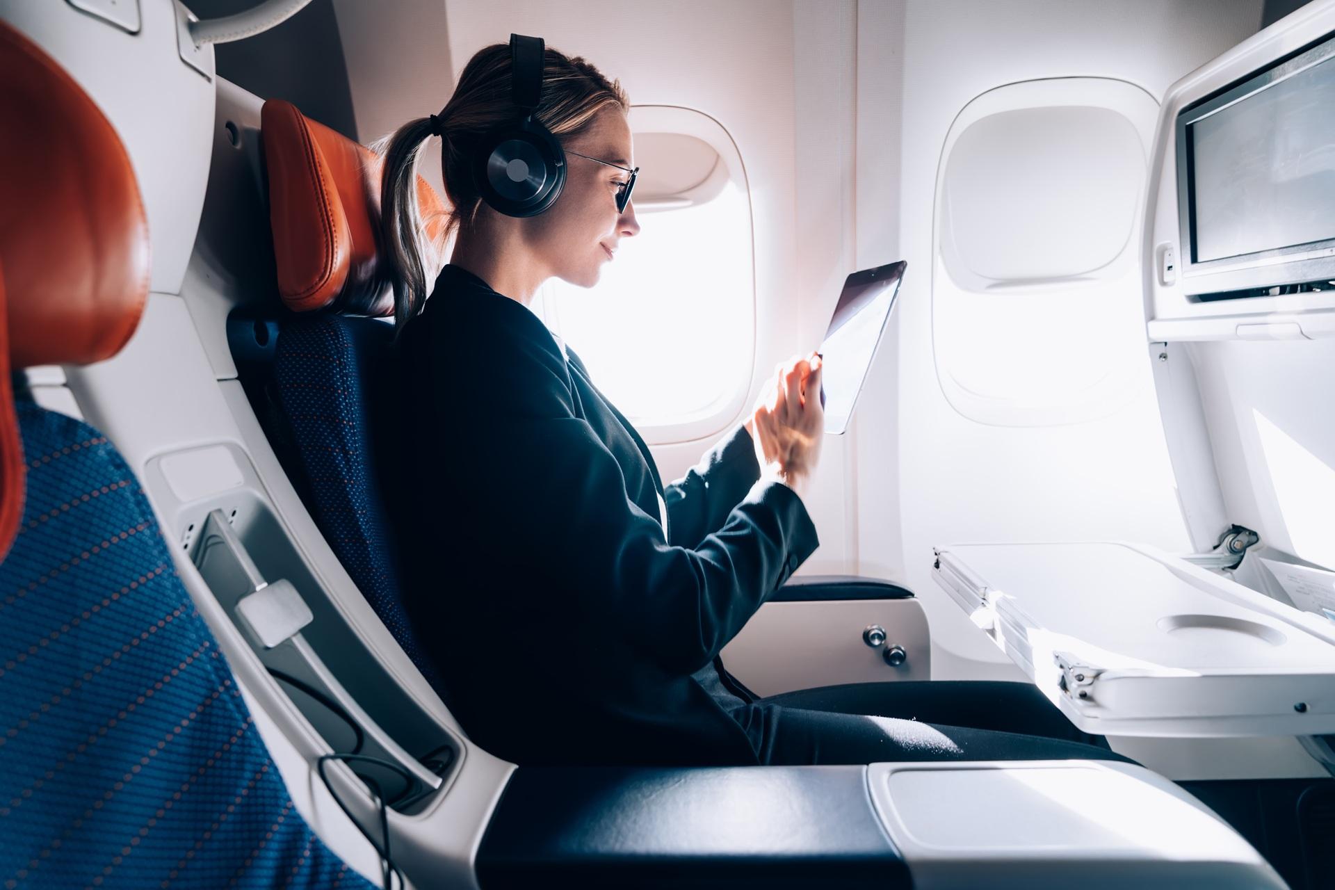Frau nutzt Tablet im Flugzeug | Einweg Vape